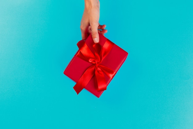 Mujer que sostiene la caja de regalo en color