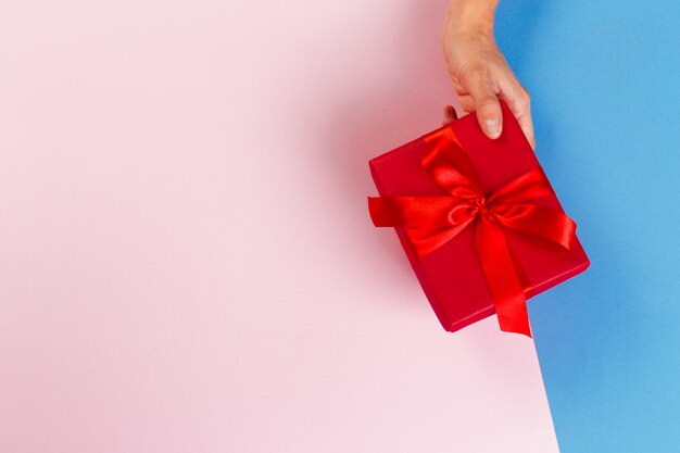 Mujer que sostiene la caja de regalo en color