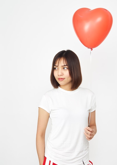 Mujer que sostiene el corazón rojo grande del globo