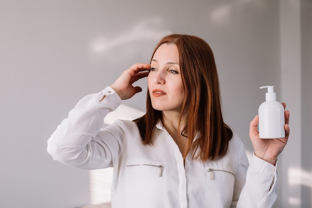 Mujer que sostiene el desinfectante antibacteriano del jabón. Concepto de coronavirus