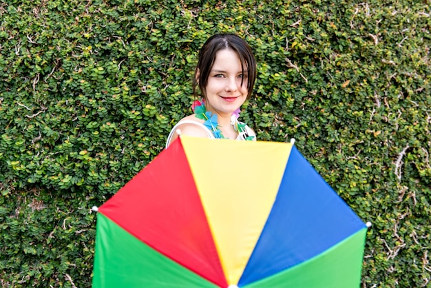 Mujer que sostiene un paraguas colorido en la fiesta de carnaval brasileña