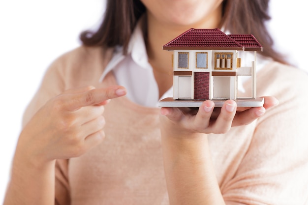 Foto mujer que sostiene la pequeña casa