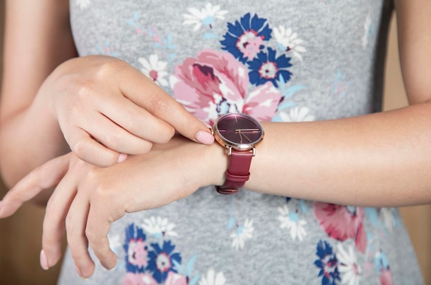 La mujer que sostiene el reloj de moda