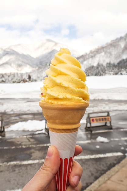 Mujer que sostiene softcream con fondo de nieve.