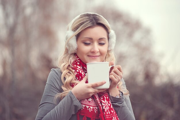 Mujer que sostiene la taza grande con chocolate caliente y bebida de chocolate y malvaviscos.