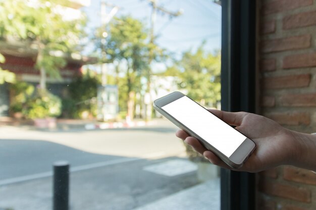 Mujer que sostiene el teléfono inteligente simulacro de pantalla en blanco, para la presentación, concepto de finanzas empresariales