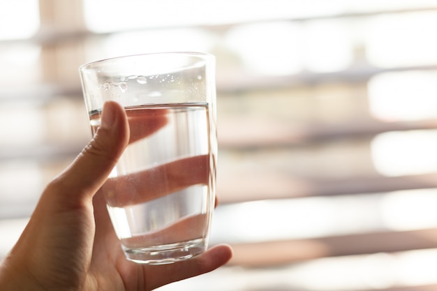 Mujer que sostiene un vaso de agua, primer plano