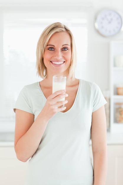 Mujer que sostiene el vaso lleno de leche