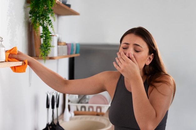 Mujer que sufre de alergia a las sustancias de limpieza