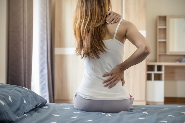 Foto mujer que sufre de dolor de espalda en la cama