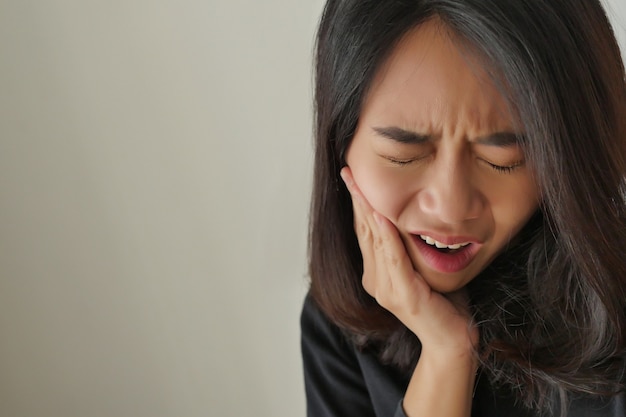 Foto mujer que sufre dolor de muelas, niña con caries, sensibilidad, concepto de tratamiento de cuidado dental