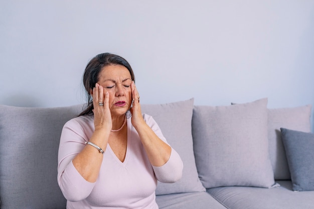 Mujer que sufre de estrés o dolor de cabeza haciendo muecas de dolor