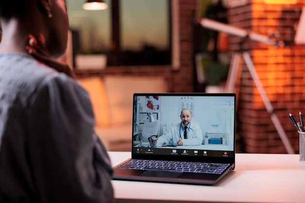 Mujer que tiene cita con el médico en videollamada usando una computadora portátil, concepto de telesalud. Consulta en línea con médico general de clínica médica profesional, servicio de telemedicina