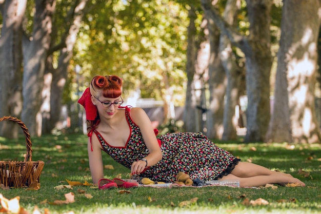 Mujer que tiene una comida campestre en el parque.