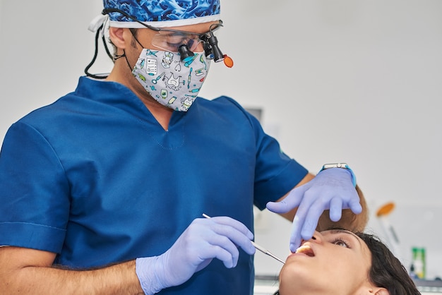 Mujer que tiene los dientes examinados en los dentistas.