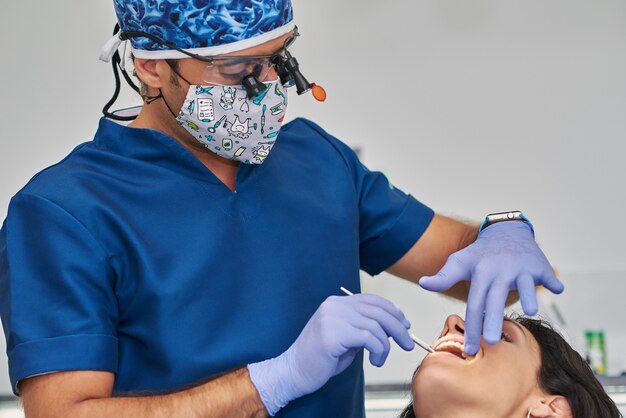 Foto mujer que tiene los dientes examinados en los dentistas.