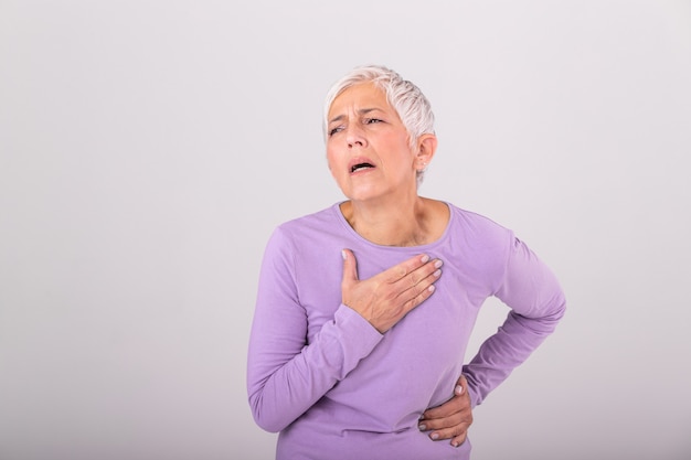 Mujer que tiene un dolor en el área del corazón. Infarto de miocardio. Cofre doloroso Cuidado de la salud, concepto médico. Alta resolución. Mujer teniendo infarto en casa