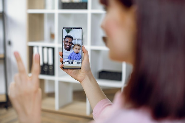 Foto mujer que tiene una videollamada con un hombre africano y su hijo