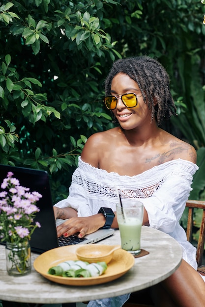 Mujer que trabaja en la cafetería al aire libre