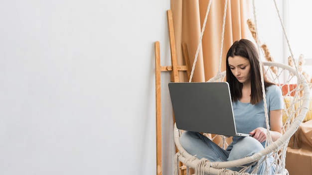 Foto mujer que trabaja en casa en la computadora portátil con espacio de copia