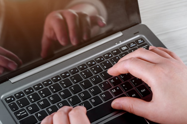 Mujer que trabaja en casa mano en cierre del teclado para arriba