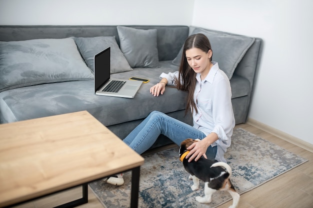 Una mujer que trabaja desde casa, su cachorro jugando junto a ella