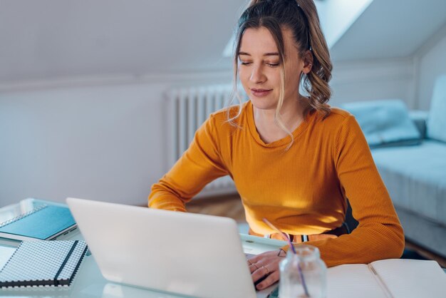 Mujer que trabaja desde una casa en su computadora portátil