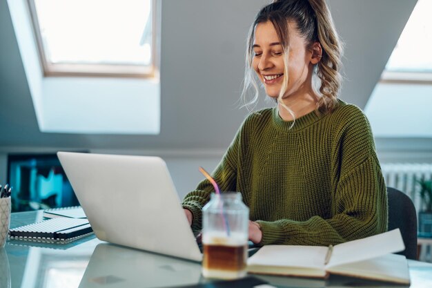 Mujer que trabaja desde una casa en su computadora portátil