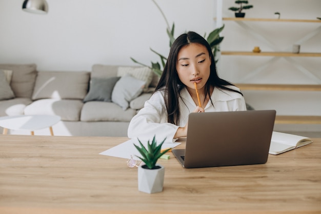 Mujer que trabaja en la computadora en el escritorio desde casa