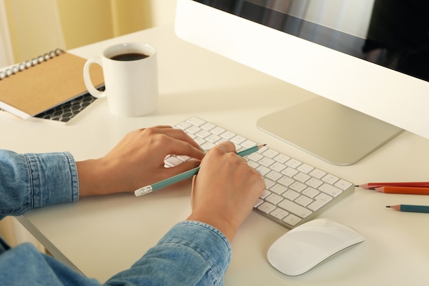 Mujer que trabaja en la computadora moderna en el cuadro blanco