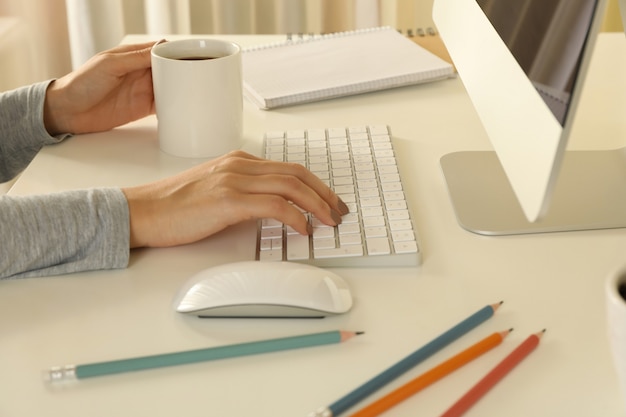 Mujer que trabaja en la computadora moderna en el cuadro blanco