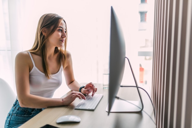 Mujer que trabaja en la computadora en la oficina en casa