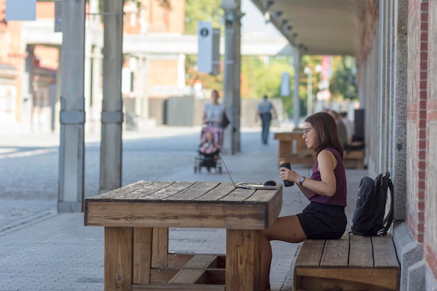 Mujer que trabaja en la computadora portátil al aire libre