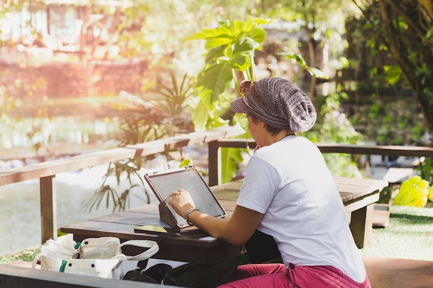 Mujer que trabaja en la computadora portátil en el café concepto de viaje al aire libre