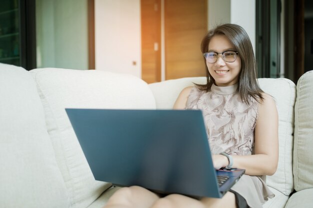 Mujer que trabaja en la computadora portátil en casa