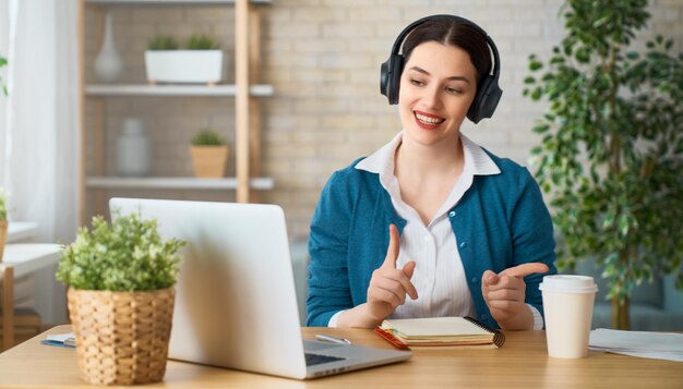 Mujer que trabaja en una computadora portátil en casa.