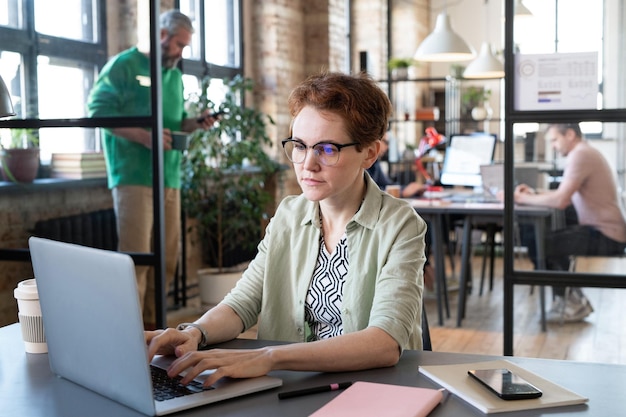 Mujer que trabaja en la computadora portátil en la oficina