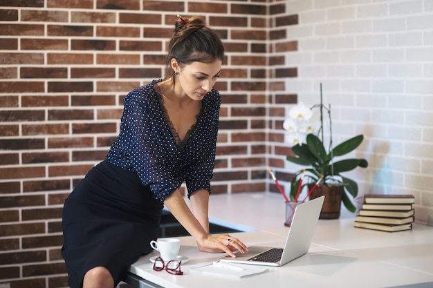 Mujer que trabaja en la computadora portátil