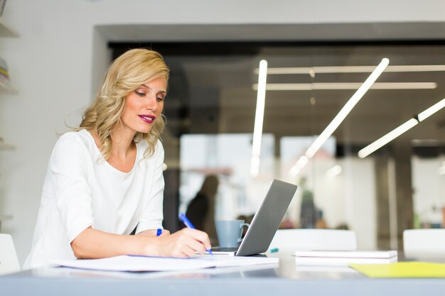 Mujer que trabaja en la computadora portátil