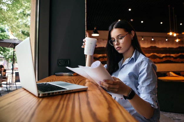 Mujer que trabaja con documentos en el café