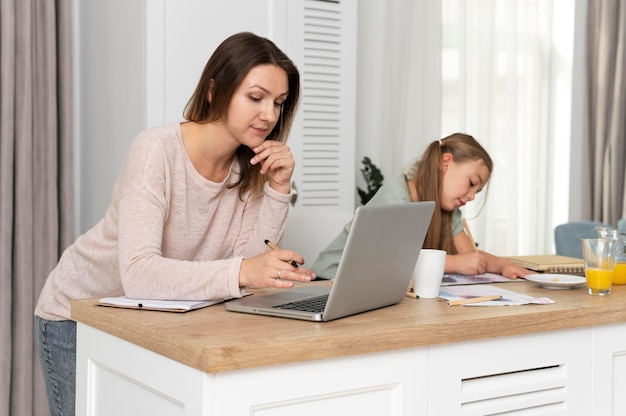 Mujer que trabaja en el escritorio con el niño