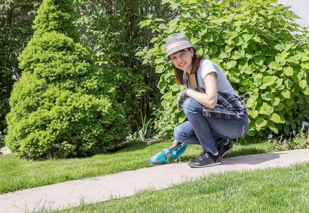 mujer que trabaja en el jardín en un día soleado