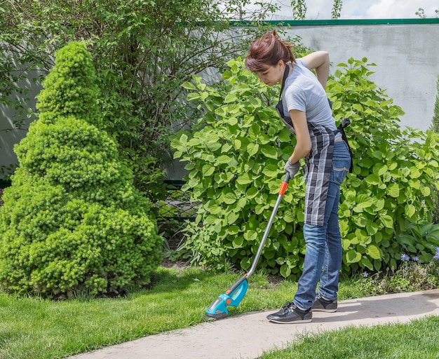 mujer que trabaja en el jardín en un día soleado