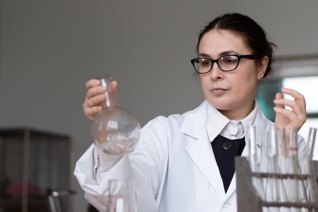 mujer que trabaja en laboratorio hemical o biológico con muestras en tubos