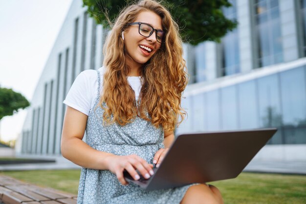 Mujer que trabaja en línea en una computadora portátil al aire libre Concepto de educación independiente de blogs de negocios