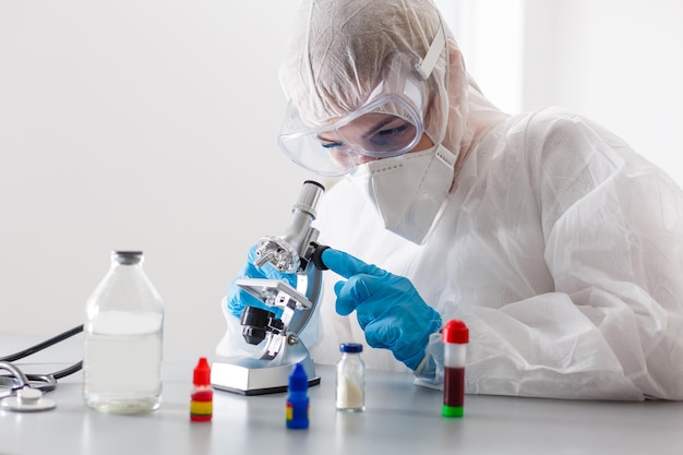 Mujer que trabaja con un microscopio en el laboratorio