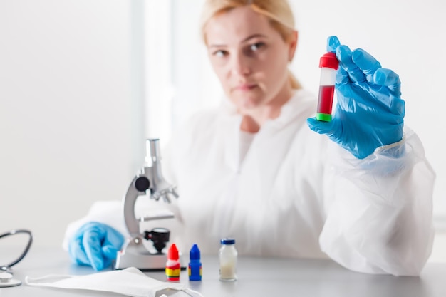 Mujer que trabaja con un microscopio en el laboratorio