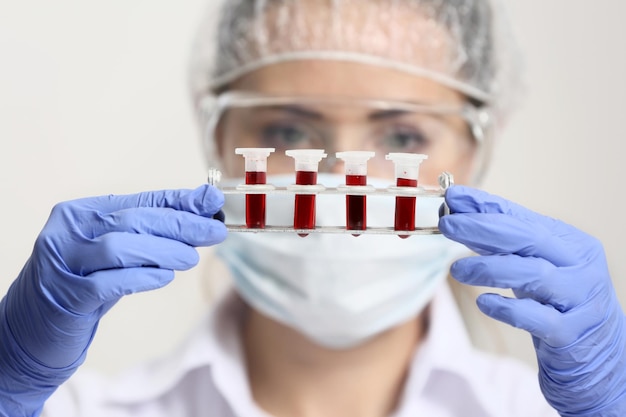 Mujer que trabaja con muestras de sangre en primer plano de laboratorio