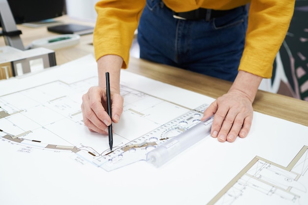 Mujer que trabaja en el plan de construcción en el escritorio