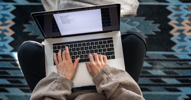 Una mujer que trabaja sentada en la vista superior de una computadora portátil